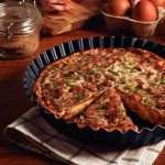 Тарт і кіш у формах з хвилястими краями на кухонному столі